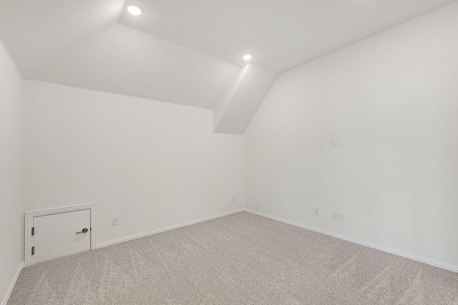 Empty bonus room with vaulted ceiling, carpet flooring, recessed lights, and small access door Empty bonus room with vaulted ceiling, carpet flooring, recessed lights, and small access door