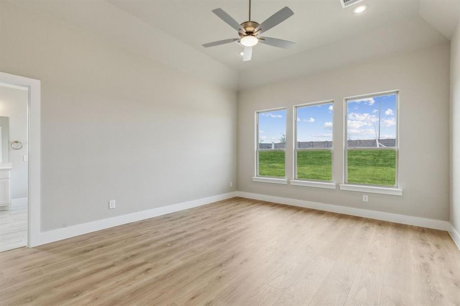 Unfurnished room with light wood-type flooring, ceiling fan, and lofted ceiling