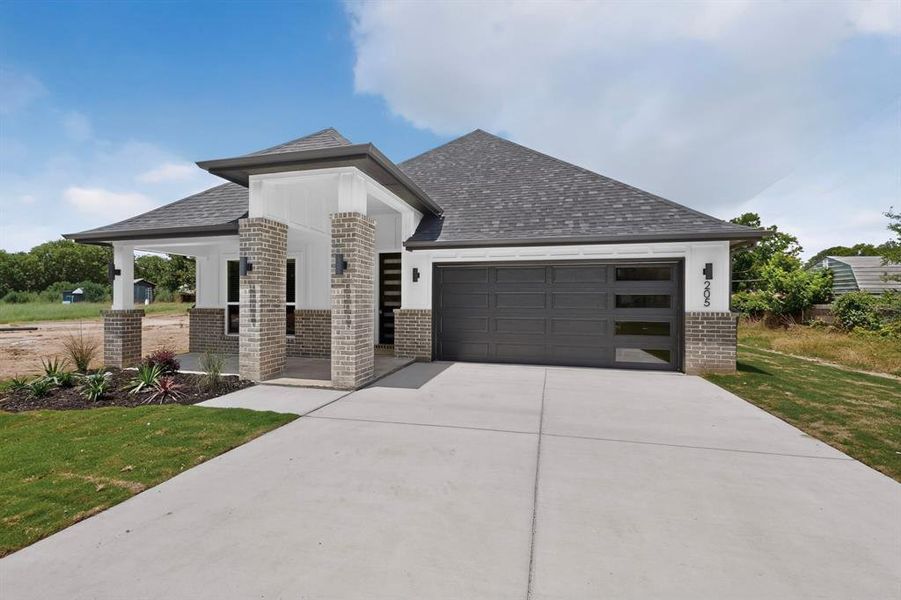 Contemporary single-story residence featuring a gray asphalt shingle roof and a light brick facade