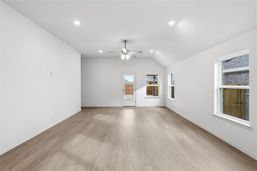 Spare room featuring ceiling fan, light wood finished floors, vaulted ceiling, and recessed lighting