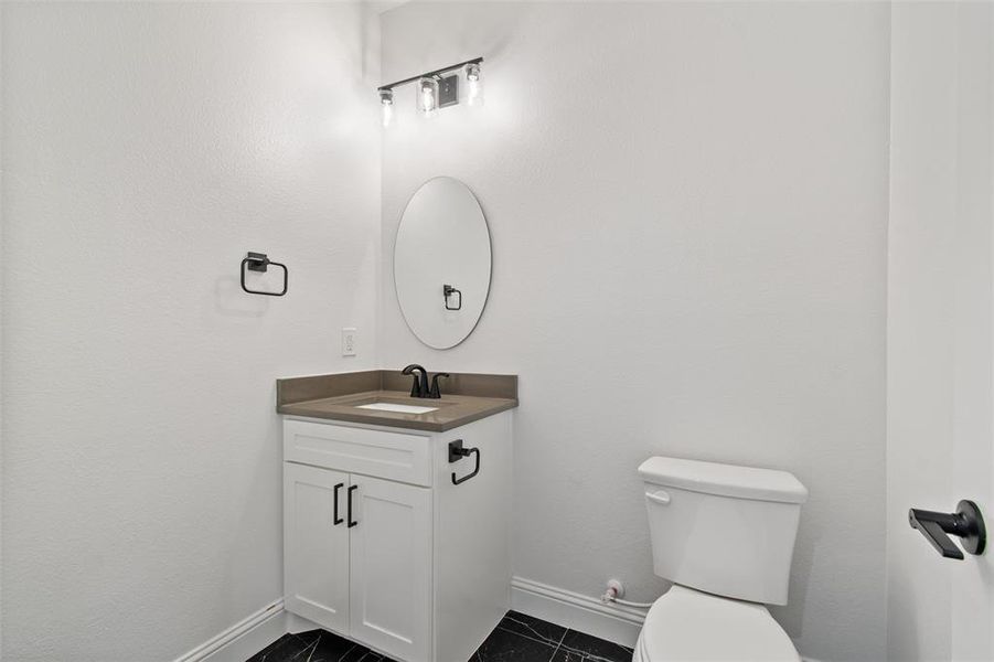 Bathroom featuring tile patterned floors, vanity, and toilet