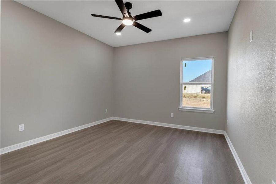 Empty room featuring dark wood finished floors, a ceiling fan, and recessed lighting