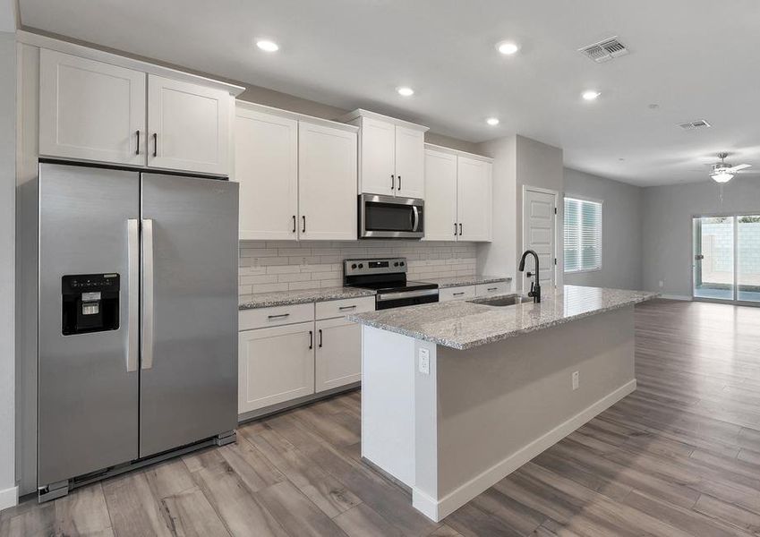 Chef-ready kitchen with stainless steel appliances, granite countertops, and white cabinets.