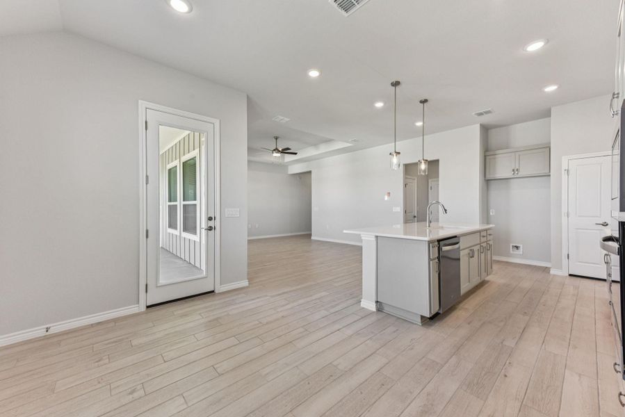 Kitchen with pendant lighting, an island with sink, open floor plan, recessed lighting, and light wood-style flooring Kitchen with pendant lighting, an island with sink, open floor plan, recessed lighting, and light wood-style flooring