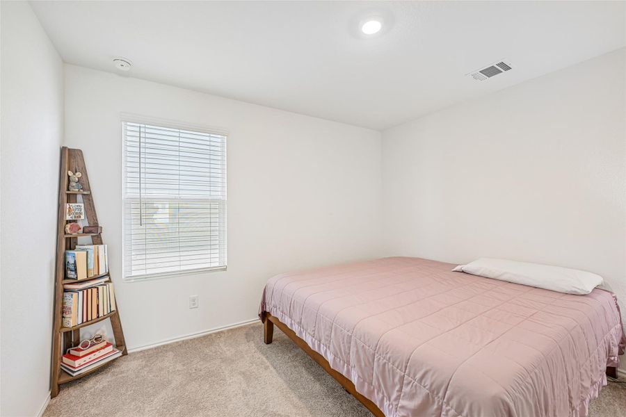 Light-filled room featuring neutral wall tones, textured carpet flooring, a window with blinds, recessed ceiling lighting, and a ceiling ventilation register Light-filled room featuring neutral wall tones, textured carpet flooring, a window with blinds, recessed ceiling lighting, and a ceiling ventilation register
