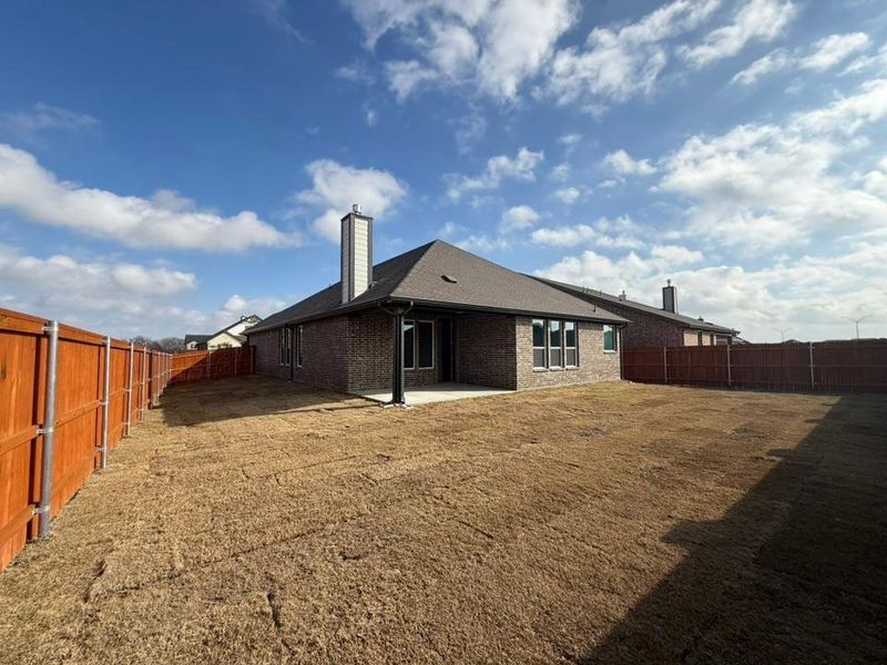 Rear view of property with a fenced backyard, a patio area, brick siding, and a chimney Rear view of property with a fenced backyard, a patio area, brick siding, and a chimney