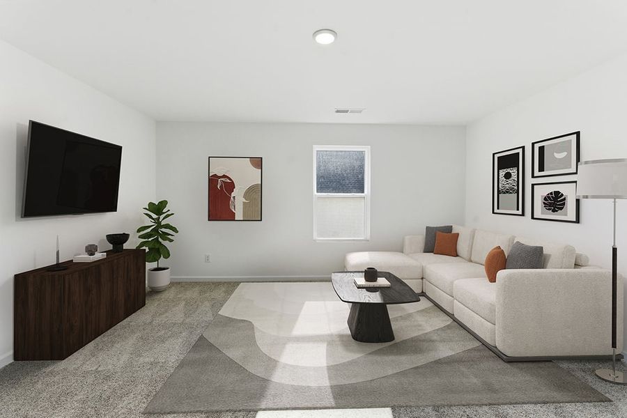 A living room with a large white couch and a tv.
