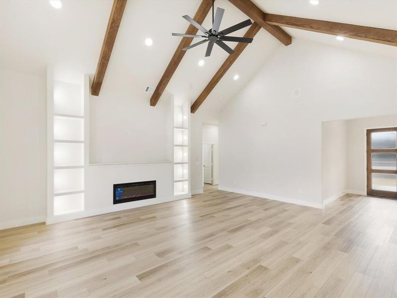 Unfurnished living room with a glass covered fireplace, a ceiling fan, recessed lighting, and light wood-style flooring