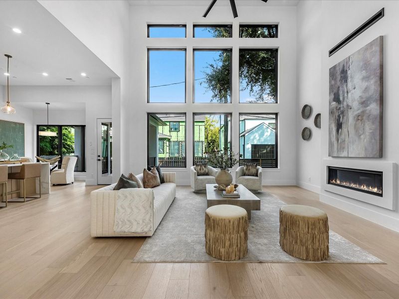 Step into the living area where the dining, breakfast, kitchen, and living spaces connect in perfect harmony. Towering windows bring in natural light, while the fireplace and upgraded fan add comfort and style.