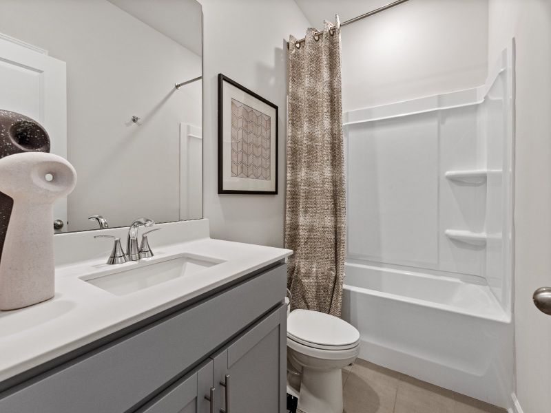 The secondary bathroom features a large vanity and oversized shower tub.