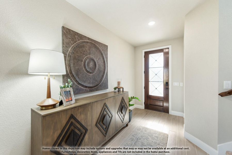 Home entryway with wood console table, decorative wall art, and glass-panel front door on light tile floors Home entryway with wood console table, decorative wall art, and glass-panel front door on light tile floors