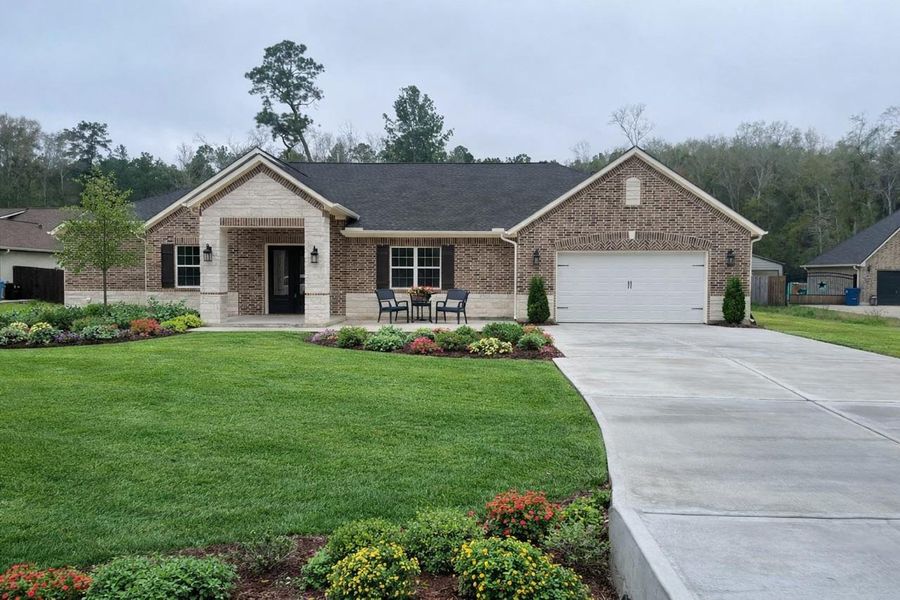 Take a look at this charming single-story brick home. It features a welcoming front porch and a long concrete driveway leading to a two-car garage.
