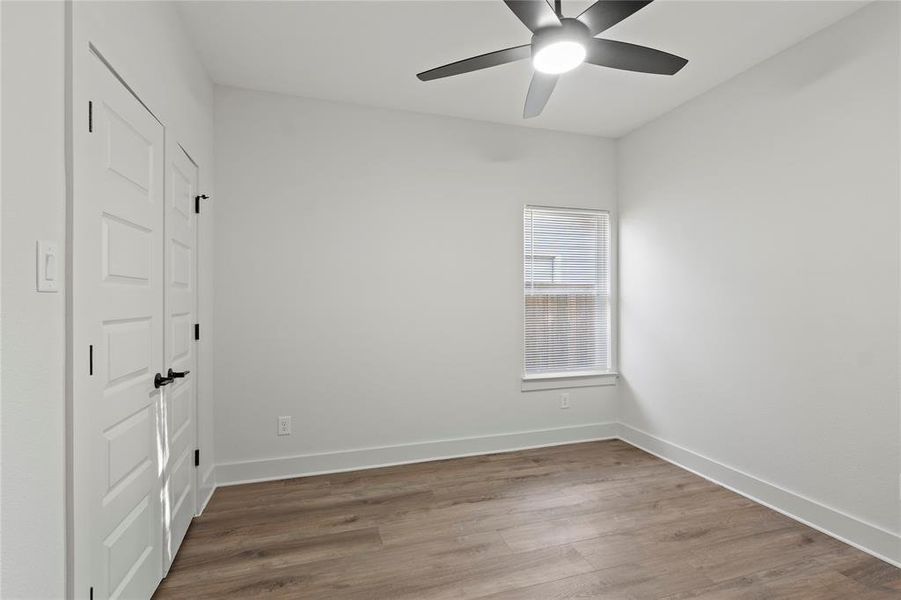 Spare room with ceiling fan, wood finished floors, and baseboards