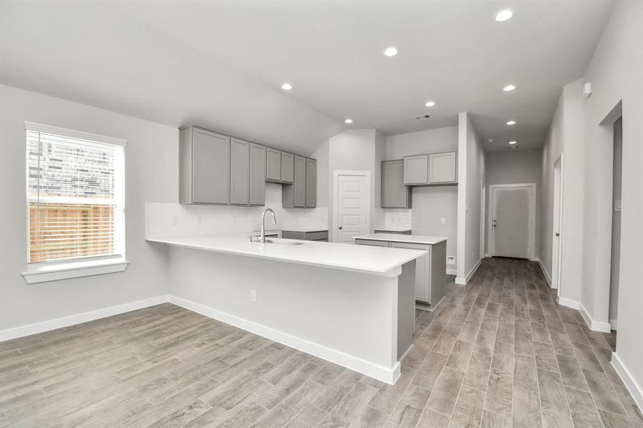 Discover another view of this spacious kitchen! Sample photo of completed home with similar floor plan. Actual colors and selections may vary.