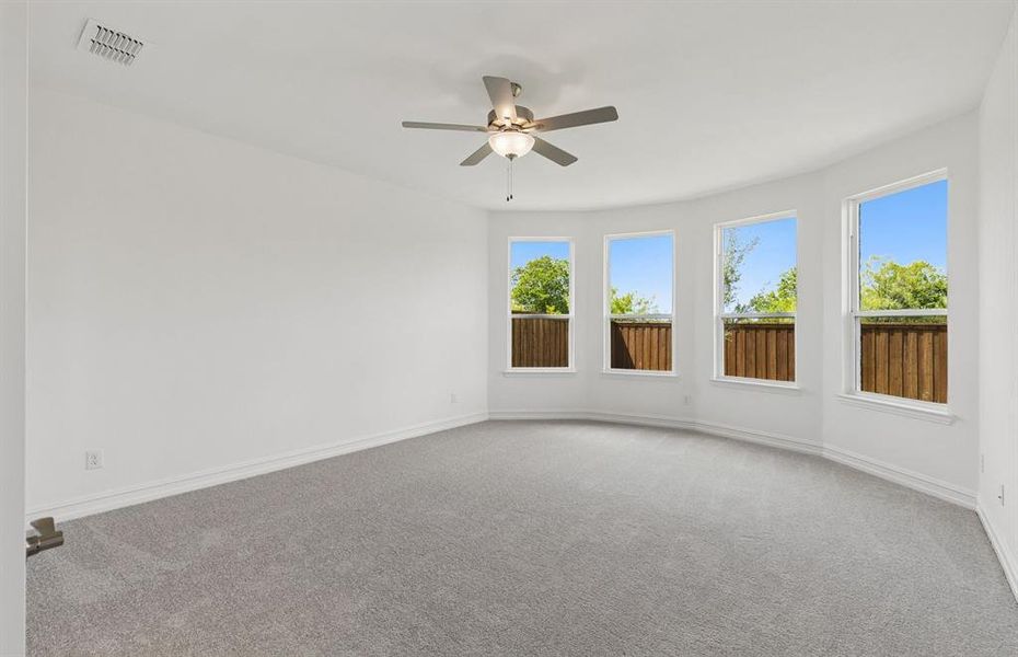 Primary bedroom with large bay windows