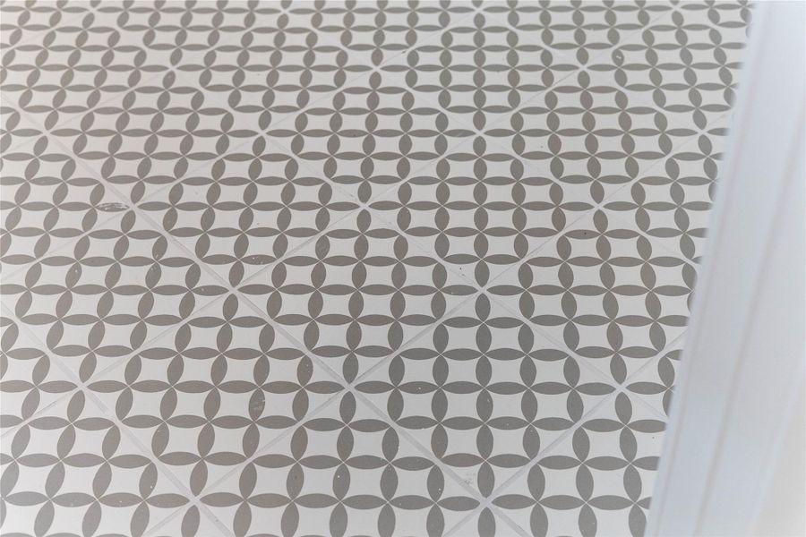 The photo highlights the stylish and durable encaustic-look tile flooring in the laundry room. This choice adds a touch of personality and flair to the space with its repeating geometric pattern of interlocking circles.