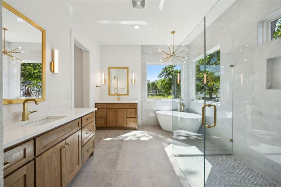 Primary bath with two vanities, a notable chandelier, a sink, and a healthy amount of sunlight Primary bath with two vanities, a notable chandelier, a sink, and a healthy amount of sunlight