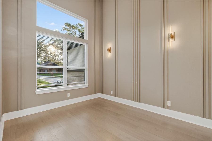 Elegant dining area features decorative wall detailing, contemporary lighting, and large windows overlooking the property. **Images are from a previously completed project. **
