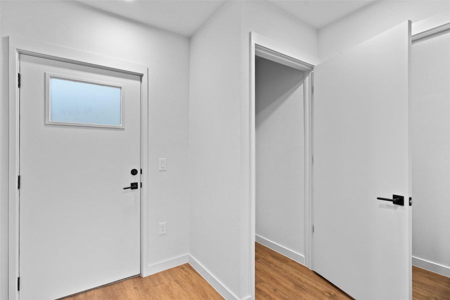 Foyer with baseboards and wood finished floors