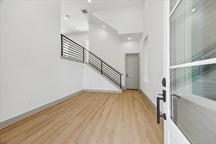 Soaring ceilings, oversized windows, and wide plank flooring create a bright, flexible space that easily adapts as a living room, home office, fitness studio, or media lounge.