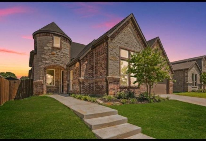 View of front of property with a garage and a lawn