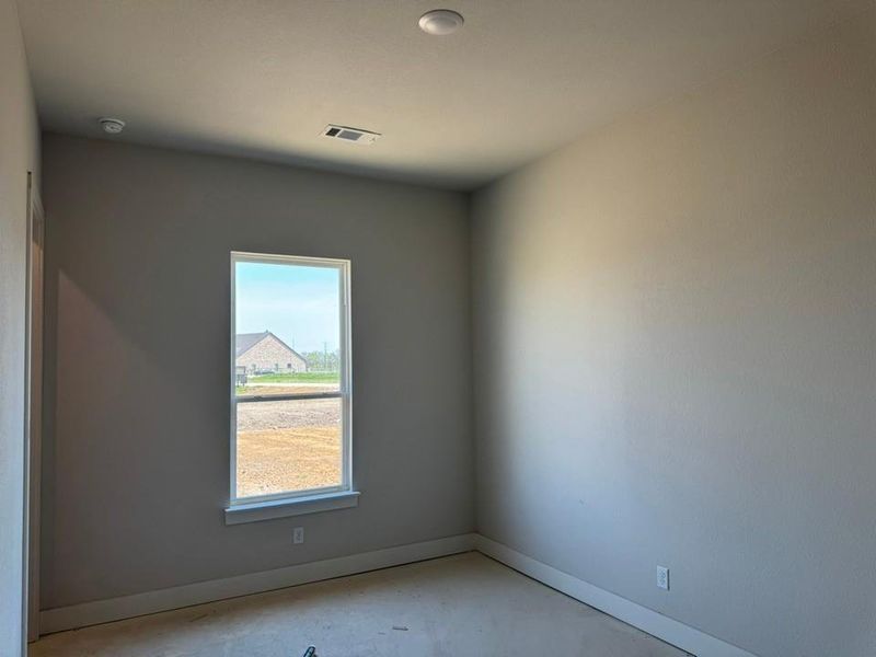 Unfurnished room with baseboards and concrete flooring