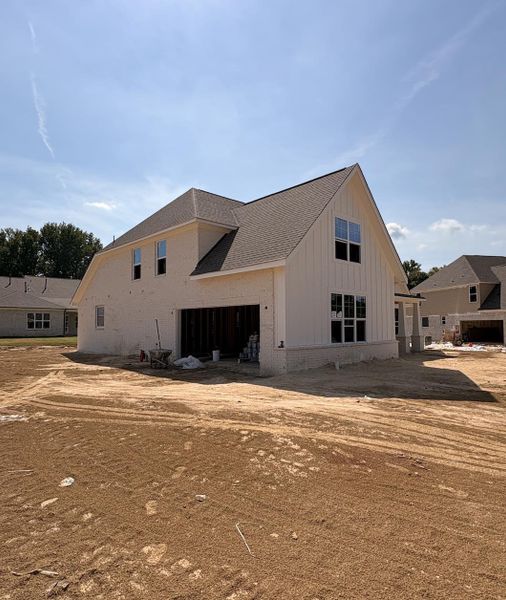 White brick exterior with board and batten accents, multi-pane windows, and a shingle roof White brick exterior with board and batten accents, multi-pane windows, and a shingle roof
