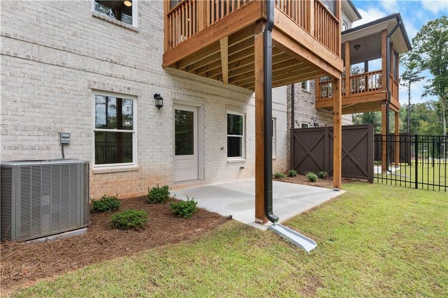 Entrance to property featuring a patio area, brick siding, a gate, and a wooden deck Entrance to property featuring a patio area, brick siding, a gate, and a wooden deck