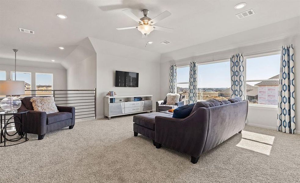 Carpeted living room with ceiling fan