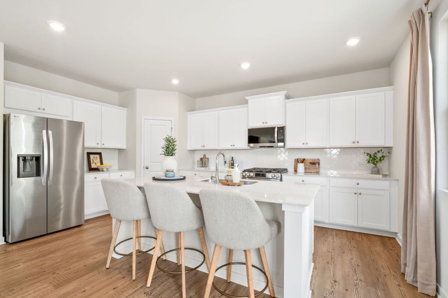 A kitchen with white cabinets.