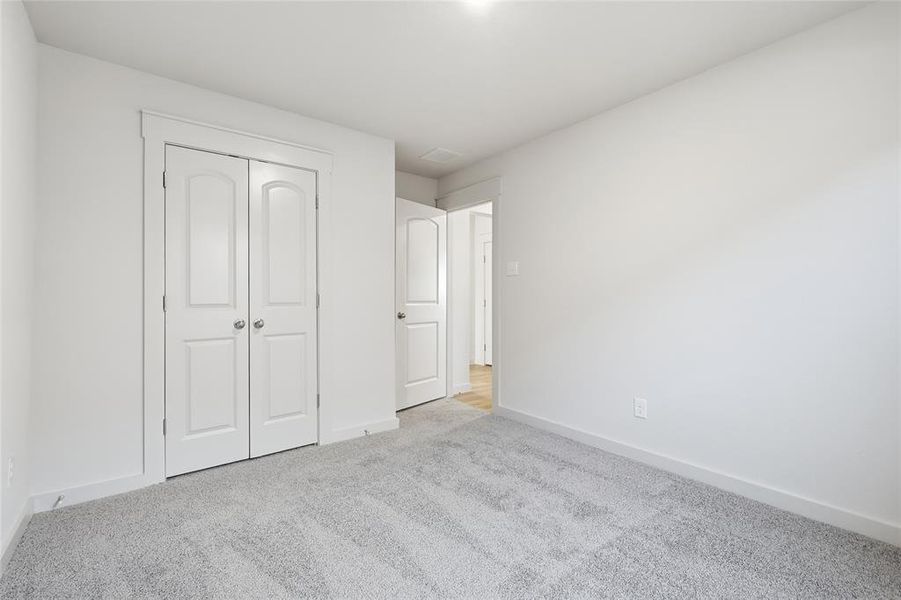 Unfurnished bedroom featuring carpet and a closet