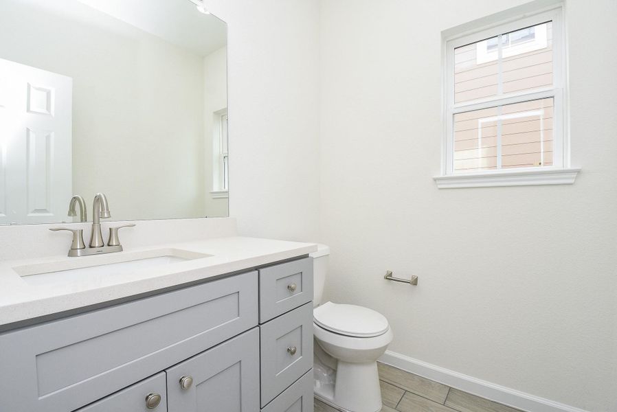 This is a bright, modern bathroom featuring a single vanity with ample storage and a large mirror, complemented by a window that provides natural light. This is a bright, modern bathroom featuring a single vanity with ample storage and a large mirror, complemented by a window that provides natural light.
