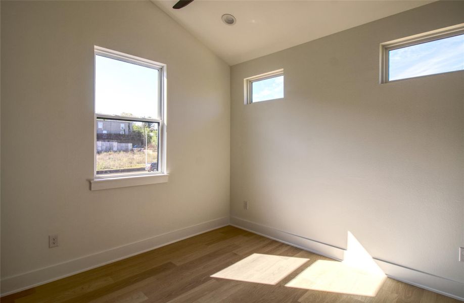 Bedroom with lofted ceiling, wood finished floors, and ceiling fan Bedroom with lofted ceiling, wood finished floors, and ceiling fan