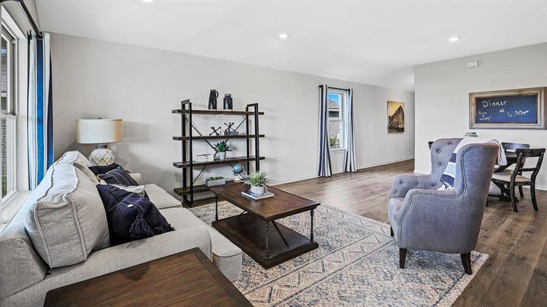 Open-concept living space featuring wood-finish flooring, recessed lighting, and ample natural light from multiple windows