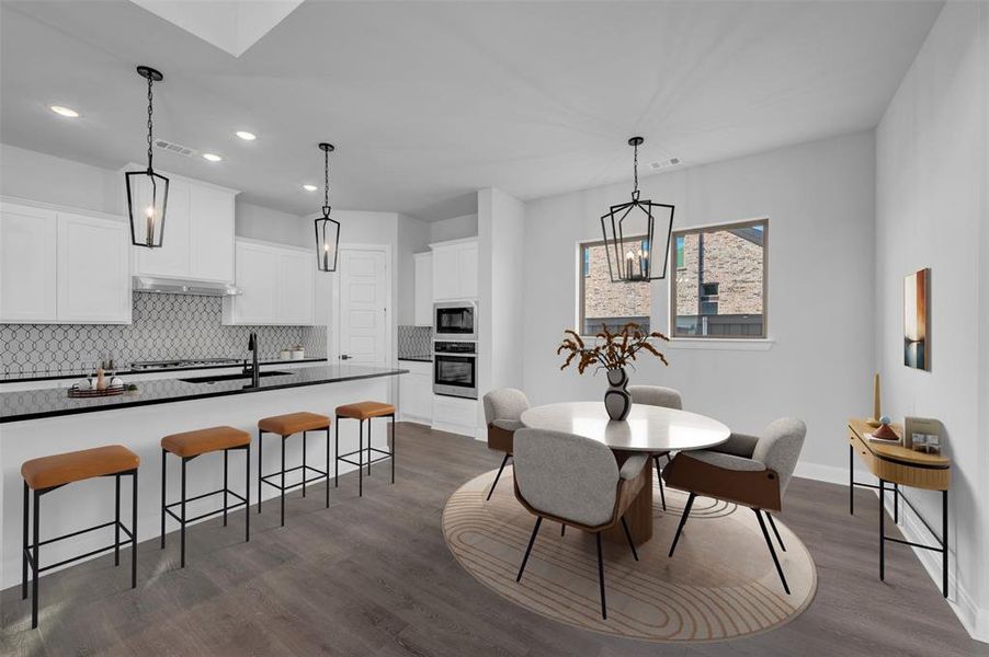Dining area featuring dark wood-style flooring and suspended lighting Dining area featuring dark wood-style flooring and suspended lighting