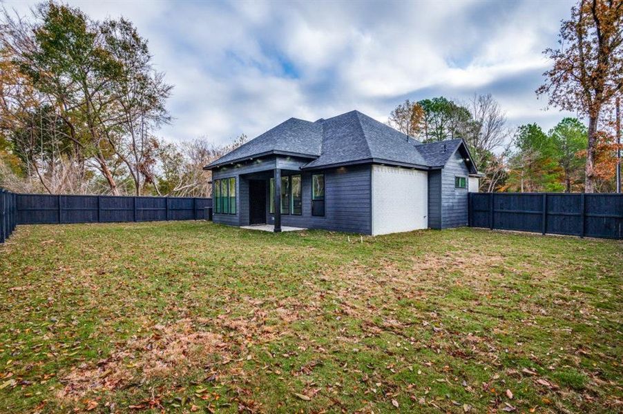 Back of house with a lawn and a patio area