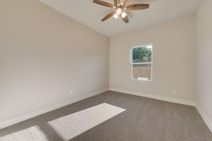 Carpeted spare room with ceiling fan