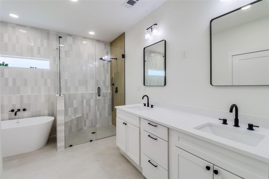 Bathroom with tile patterned flooring, visible vents, a sink, and a shower stall