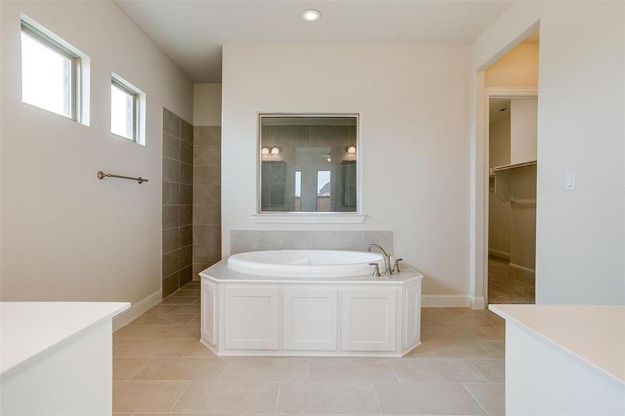 Bathroom with tile patterned flooring and a bathtub