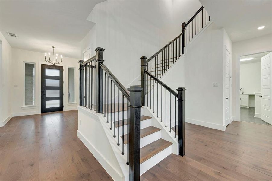 Entryway with suspended lighting and dark wood-type flooring