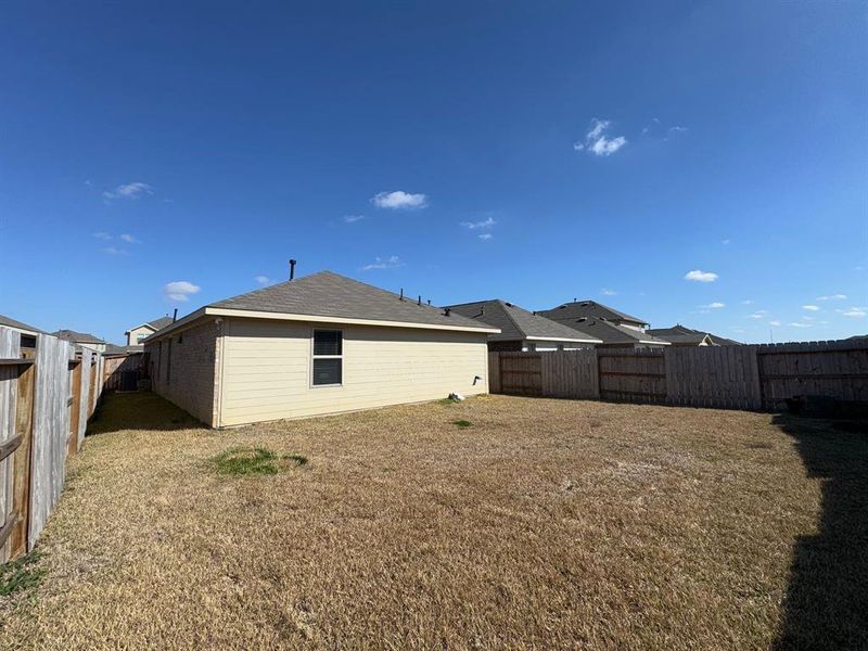 The spacious backyard offers plenty of room for outdoor activities, with an open space perfect for hosting gatherings, playing, or relaxing.