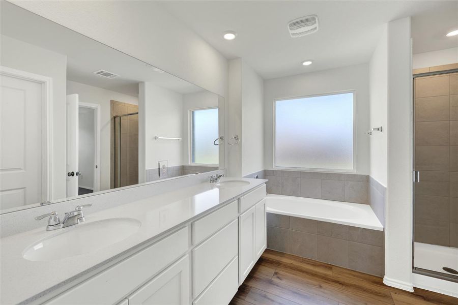 Dual vanities and a deep soaking tub create a luxurious primary bathroom retreat.