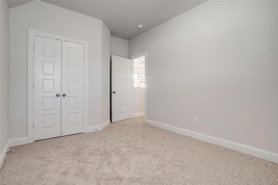 Unfurnished bedroom featuring light colored carpet and a closet