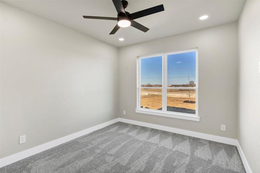 Empty room with ceiling fan and carpet