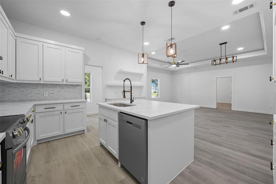 Kitchen with hanging light fixtures, white cabinetry, range with electric cooktop, stainless steel dishwasher, and light wood-style floors Kitchen with hanging light fixtures, white cabinetry, range with electric cooktop, stainless steel dishwasher, and light wood-style floors