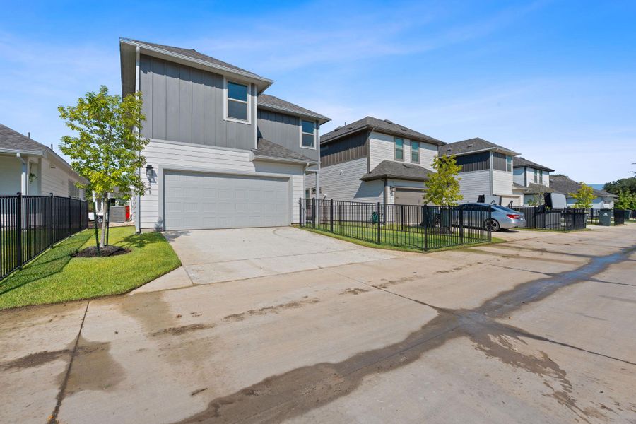 Traditional-style home featuring a residential view, concrete driveway, an attached garage, board and batten siding, and roof with shingles Traditional-style home featuring a residential view, concrete driveway, an attached garage, board and batten siding, and roof with shingles