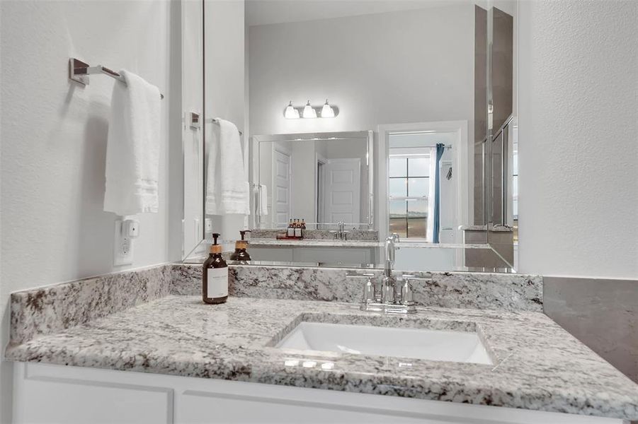 Bathroom featuring vanity and a textured wall