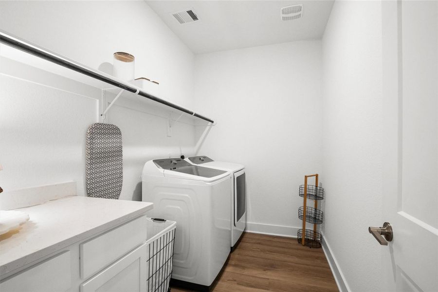 Spacious laundry room with plenty of room to keep everyday tasks organized, featuring a built-in countertop for folding and convenient hanging space for added functionality.