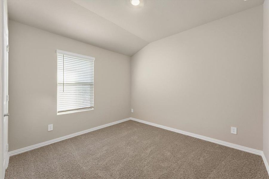 Unfurnished room featuring lofted ceiling and carpet flooring Unfurnished room featuring lofted ceiling and carpet flooring