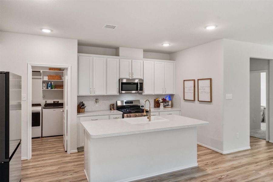 stainless steel appliances and upgraded sink in this pristine kitchen